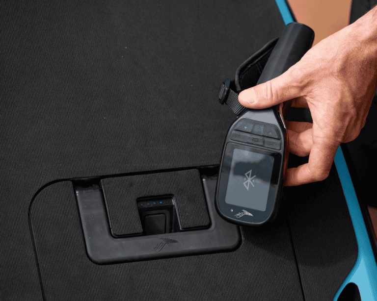 Hand holding Lift eFoil remote above deck-mounted charging port