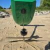 Rear view of a custom green electric hydrofoil eFoil board with foil mast, propulsion system, and hydrofoil wings on the sand at Buckroe Beach in Hampton, Virginia.
