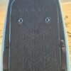 Close-up of a custom light blue eFoil board deck with black traction pad, hatch latches, and carry handles on the beach at Buckroe Beach in Hampton, Virginia.