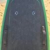 Close-up of a green eFoil board deck with black traction pad, carry handles, and storage hatch on the beach at Buckroe Beach in Hampton, Virginia.