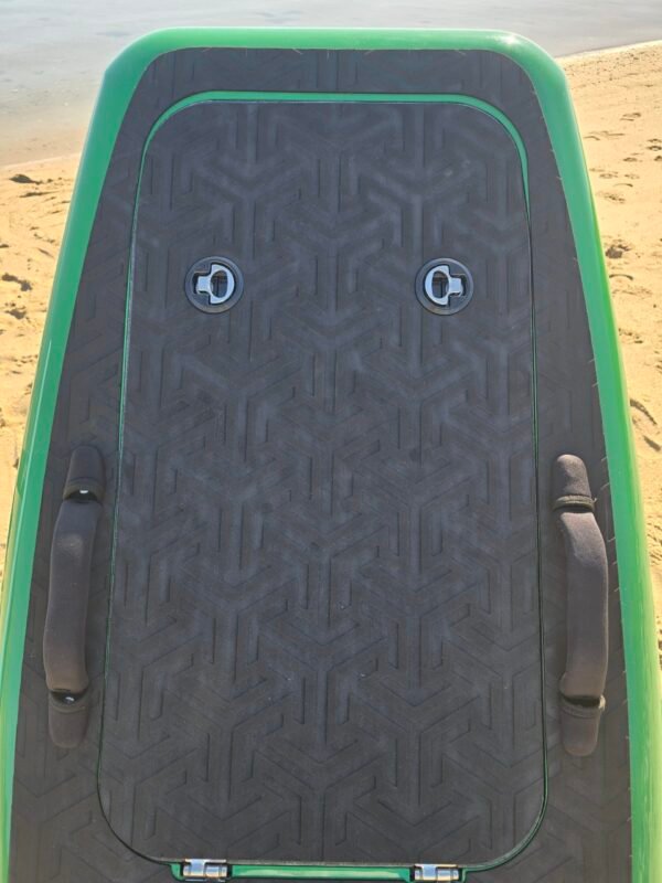 Close-up of a green eFoil board deck with black traction pad, carry handles, and storage hatch on the beach at Buckroe Beach in Hampton, Virginia.